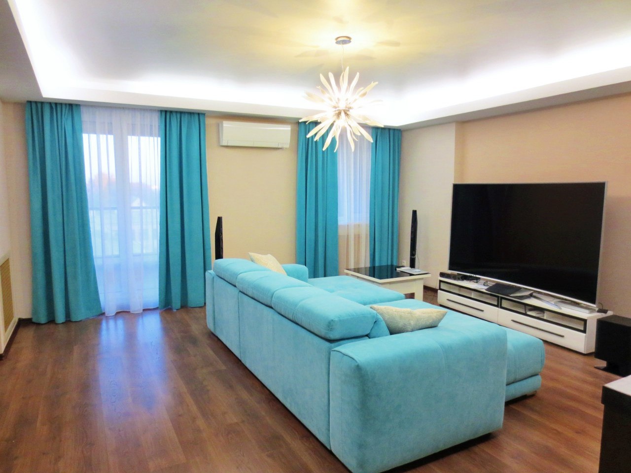 интерьер с бирюзовым диваном и шторами